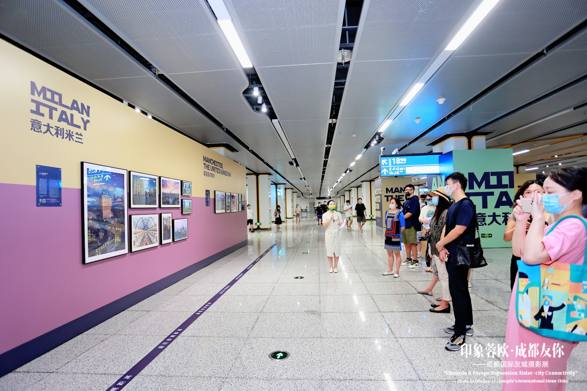 Corridoio della mostra a Chengdu con i visitatori riuniti davanti alla parete dedicata a Milano.