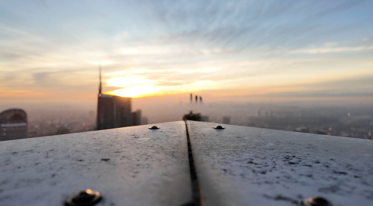 Dettaglio della terrazza panoramica all'alba, con la Torre Unicredit sullo sfondo sfocato.