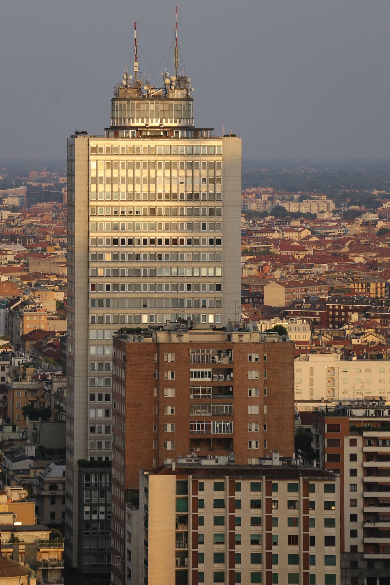 Facciata della Torre Breda in grès ceramico, illuminata dalla luce dorata del tramonto.