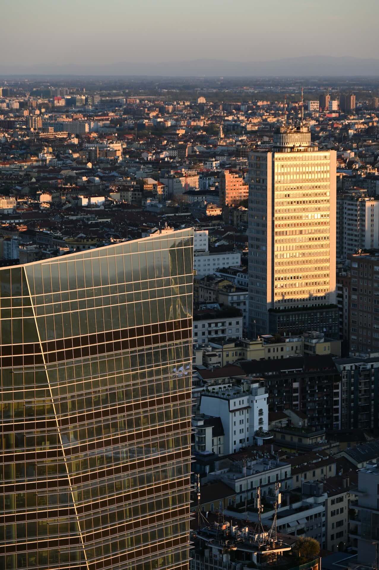 Torre Breda al tramonto accanto alla facciata vetrata della Torre BNP Paribas.