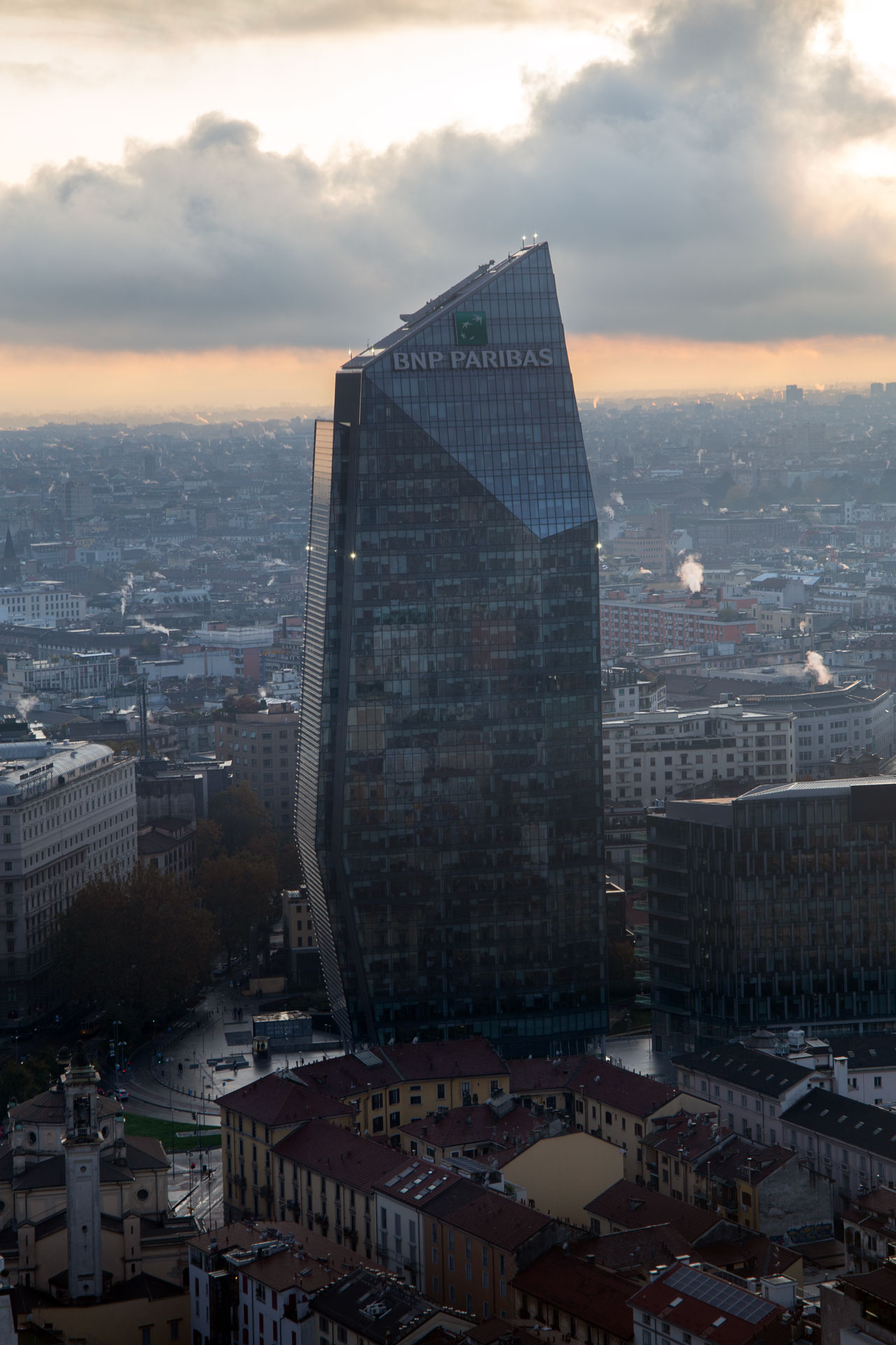 La facciata della Torre Diamante che riflette la luce dorata del tramonto, come un cristallo.