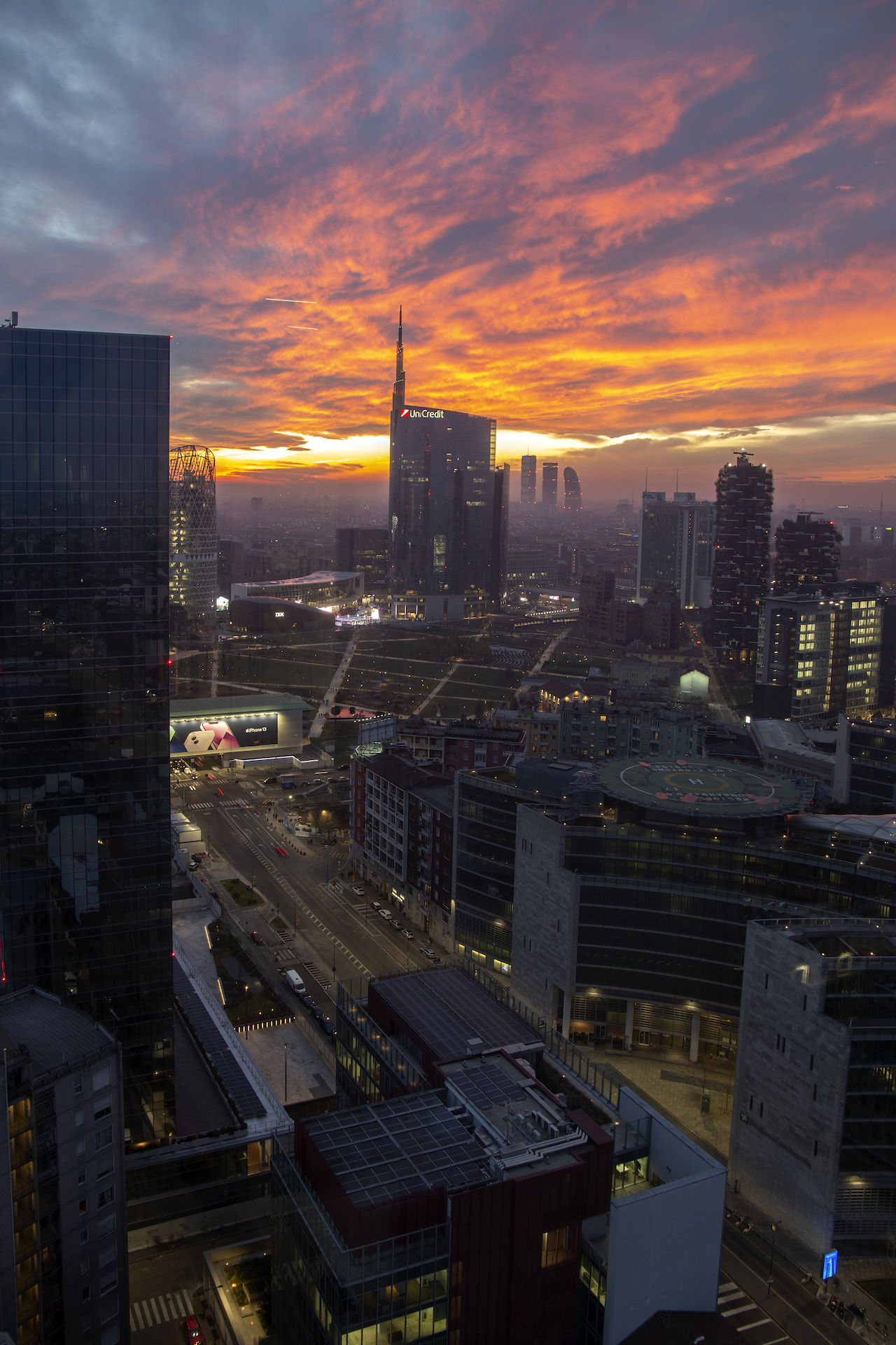 Vista dalla terrazza della Torre Galfa verso la Torre Unicredit al tramonto, con l'eliporto in primo piano.