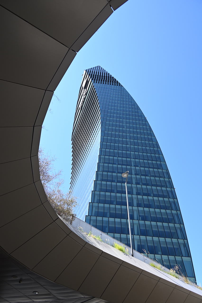 La Torre PwC incorniciata dall'apertura curva di un edificio residenziale di CityLife.