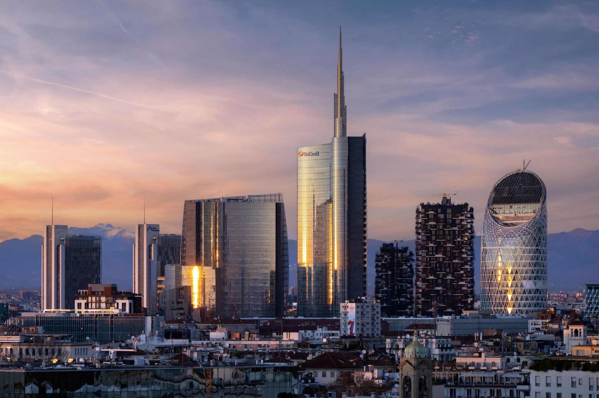 Panoramica al tramonto della Torre Unicredit con le Alpi visibili all'orizzonte.